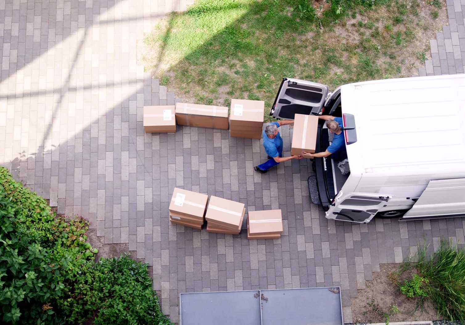 Young delivery men loading cardboard boxes in truck in Newtownabbey
