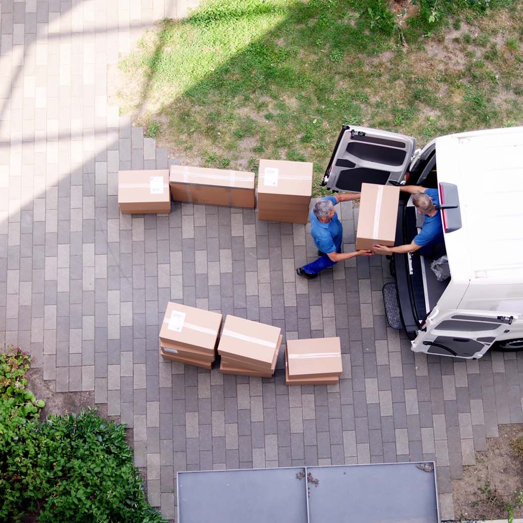 Young delivery men loading cardboard boxes in truck in Newtownabbey